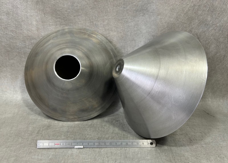 Cône en aluminium réalisé par fluotournage, posé sur un mandrin de contrôle. Pièce industrielle issue d’une série de 200 unités, avec finition usinée et tronçonnage précis. Procédé de déformation plastique à froid pour une géométrie conique optimisée.